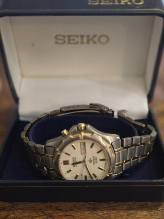 Seiko Kinetic Titanium SQ100 wristwatch with black dial and silver band, showcasing sleek, modern design and precise timekeeping.