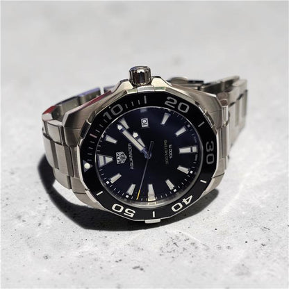 TAG Heuer Aquaracer 300 meters diving watch with black dial, stainless steel bracelet, and rotating bezel.