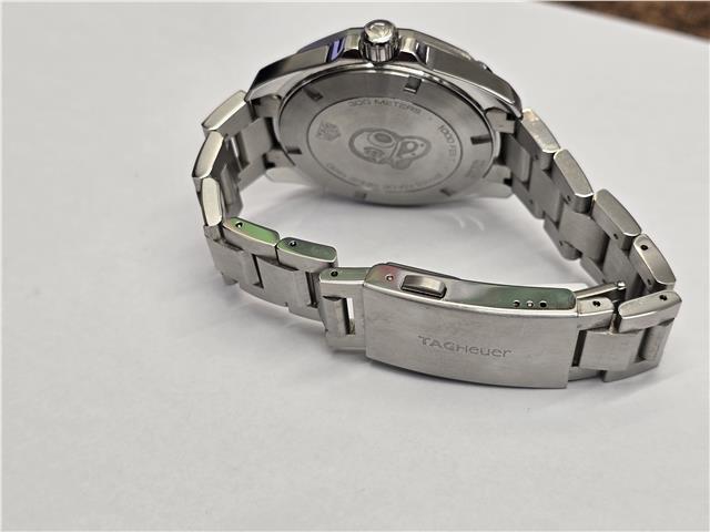 Tag Heuer Aquaracer 300 meters diving watch with black dial and stainless steel bracelet.
