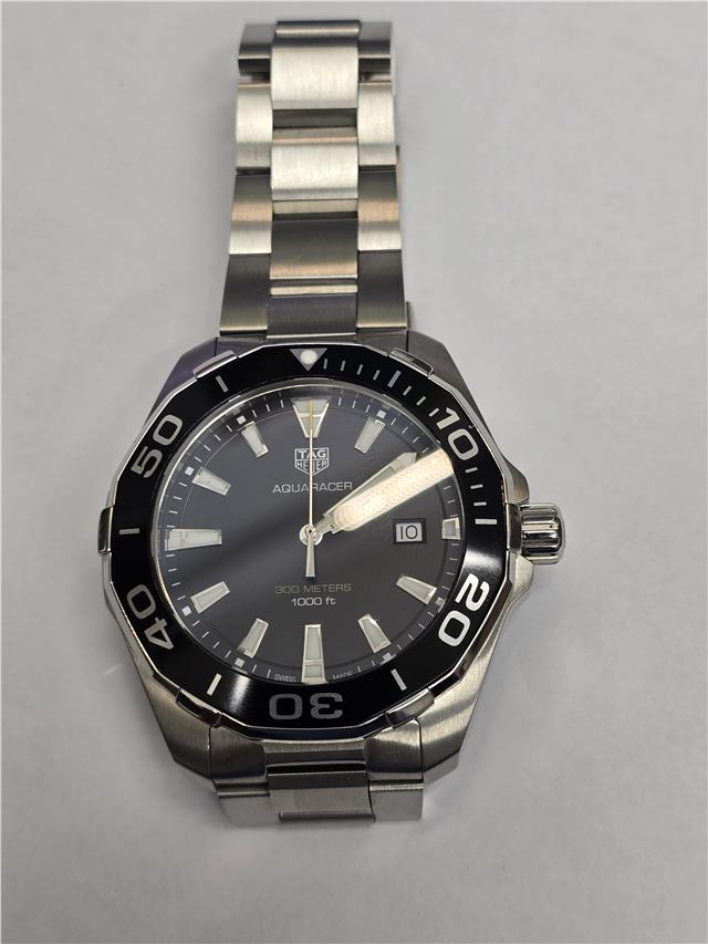 TAG Heuer Aquaracer 300 meters wristwatch with black dial, stainless steel case, and rotating bezel.