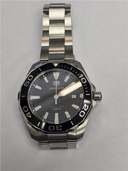 TAG Heuer Aquaracer 300 meters wristwatch with black dial, stainless steel case, and rotating bezel.