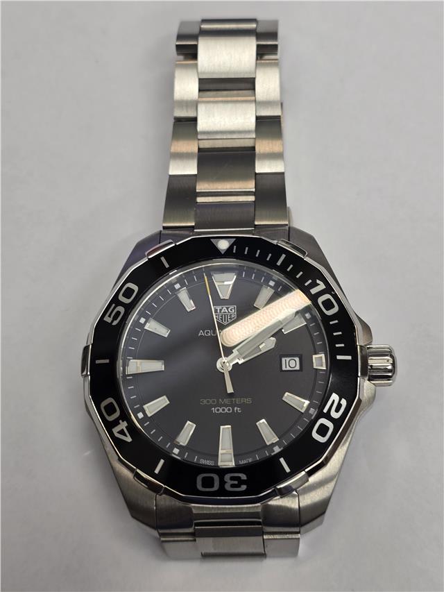 TAG Heuer Aquaracer 300 meters diving watch with black dial, stainless steel band, and unidirectional bezel.