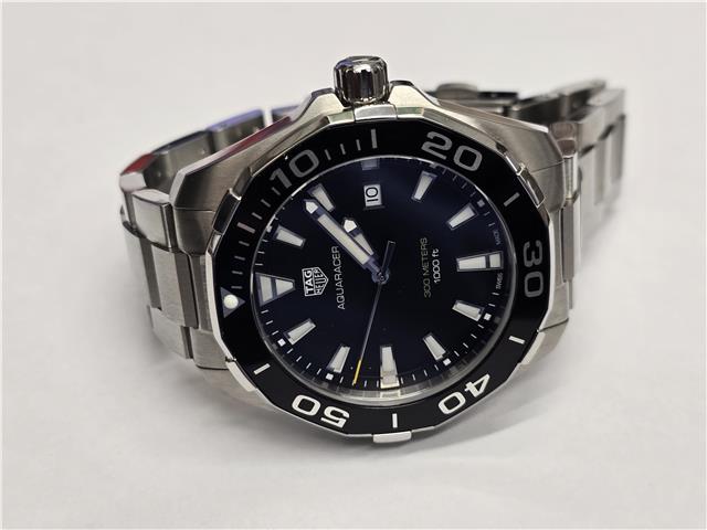 TAG Heuer Aquaracer 300M diving watch with black dial, stainless steel bracelet, and rotating bezel.