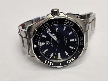 TAG Heuer Aquaracer 300M diving watch with black dial, stainless steel bracelet, and rotating bezel.