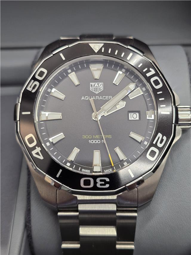 TAG Heuer Aquaracer 300 meters diving watch with black dial, stainless steel case, and unidirectional bezel.