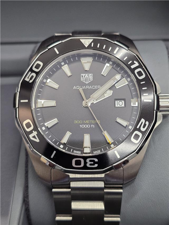 TAG Heuer Aquaracer 300 meters diving watch with black dial, stainless steel band, and unidirectional bezel.