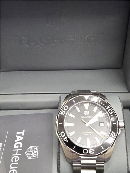 TAG Heuer Aquaracer 300 meters diving watch with black dial and stainless steel bracelet, showcasing sporty design and water resistance.