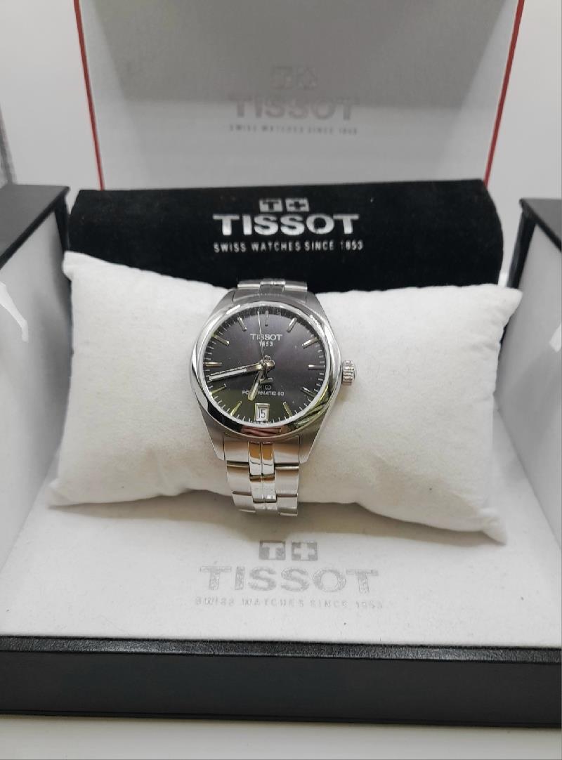 Tissot PR100 watch with box and papers, featuring a stainless steel case and black dial.