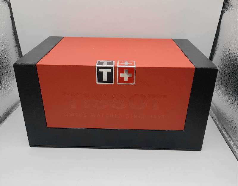 Tissot PR100 watch with box and papers, featuring a stainless steel band and classic dial design.