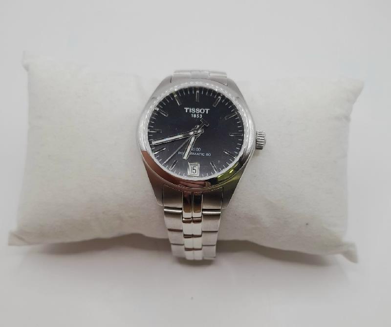 Tissot PR100 watch with box and papers, featuring a stainless steel band and classic dial, displayed in the image.
