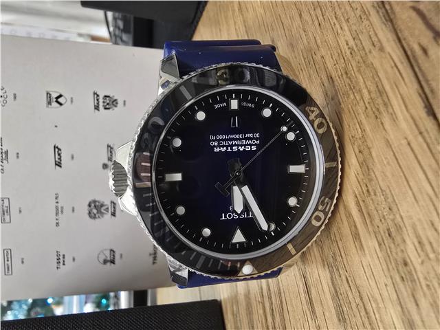 Tissot Seastar Power Matic 80 watch with box and papers, featuring a stainless steel case and black dial.
