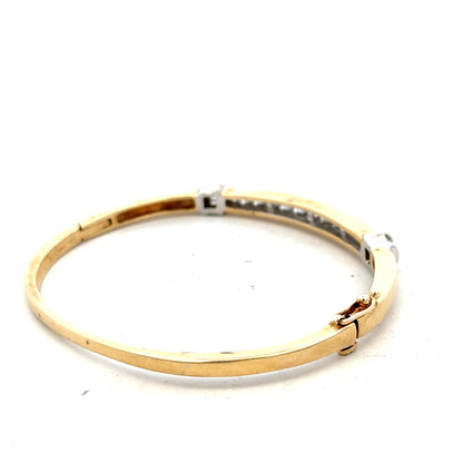 14ct yellow gold diamond bangle with 1 carat total weight, featuring sparkling diamonds and a sleek design.