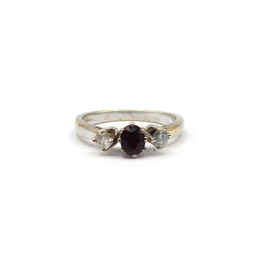 18ct white gold ring featuring a 0.24 carat diamond and 0.45 carat garnet, showcasing elegant jewelry craftsmanship.