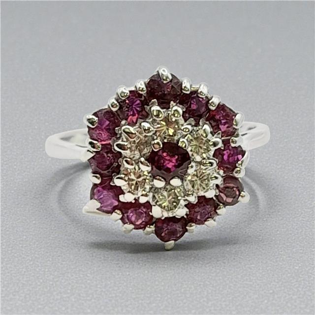 18ct white gold ring with diamonds and rubies, featuring a detailed design on a plain background.