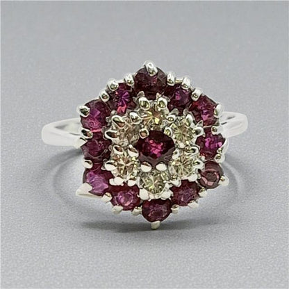 18ct white gold ring with diamonds and rubies, featuring a detailed design on a plain background.