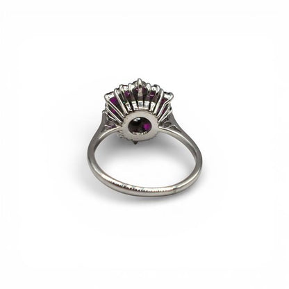 18ct white gold diamond and ruby ring with sparkling gemstones and intricate band design on a neutral background.