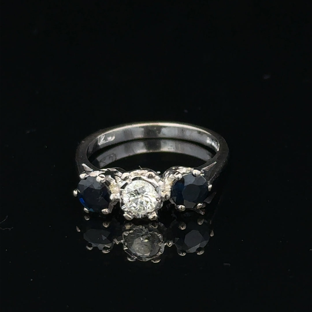 18ct white gold sapphire and diamond ring featuring a central blue sapphire surrounded by sparkling diamonds.