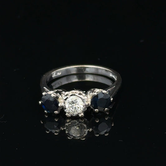 18ct white gold sapphire and diamond ring featuring a central blue sapphire surrounded by sparkling diamonds.