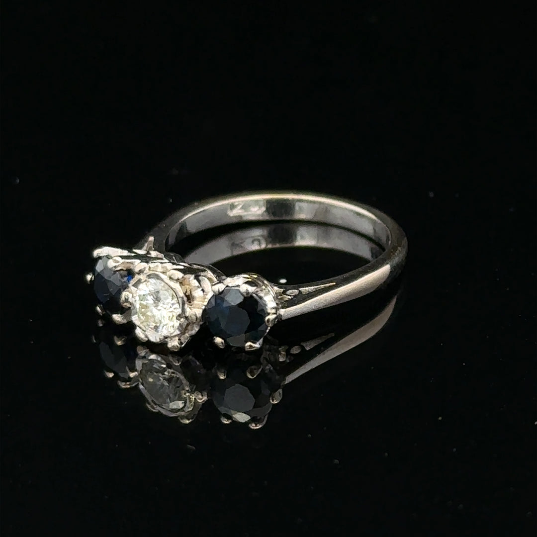 18ct white gold sapphire and diamond ring with a central blue sapphire surrounded by sparkling diamonds.