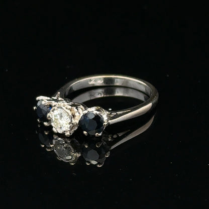 18ct white gold sapphire and diamond ring with a central blue sapphire surrounded by sparkling diamonds.
