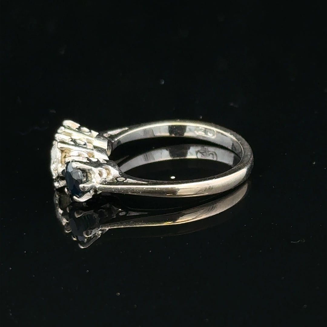 18ct white gold sapphire and diamond ring featuring a central blue sapphire gemstone and sparkling diamond accents.