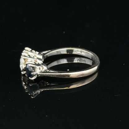 18ct white gold sapphire and diamond ring featuring a central blue sapphire gemstone and sparkling diamond accents.