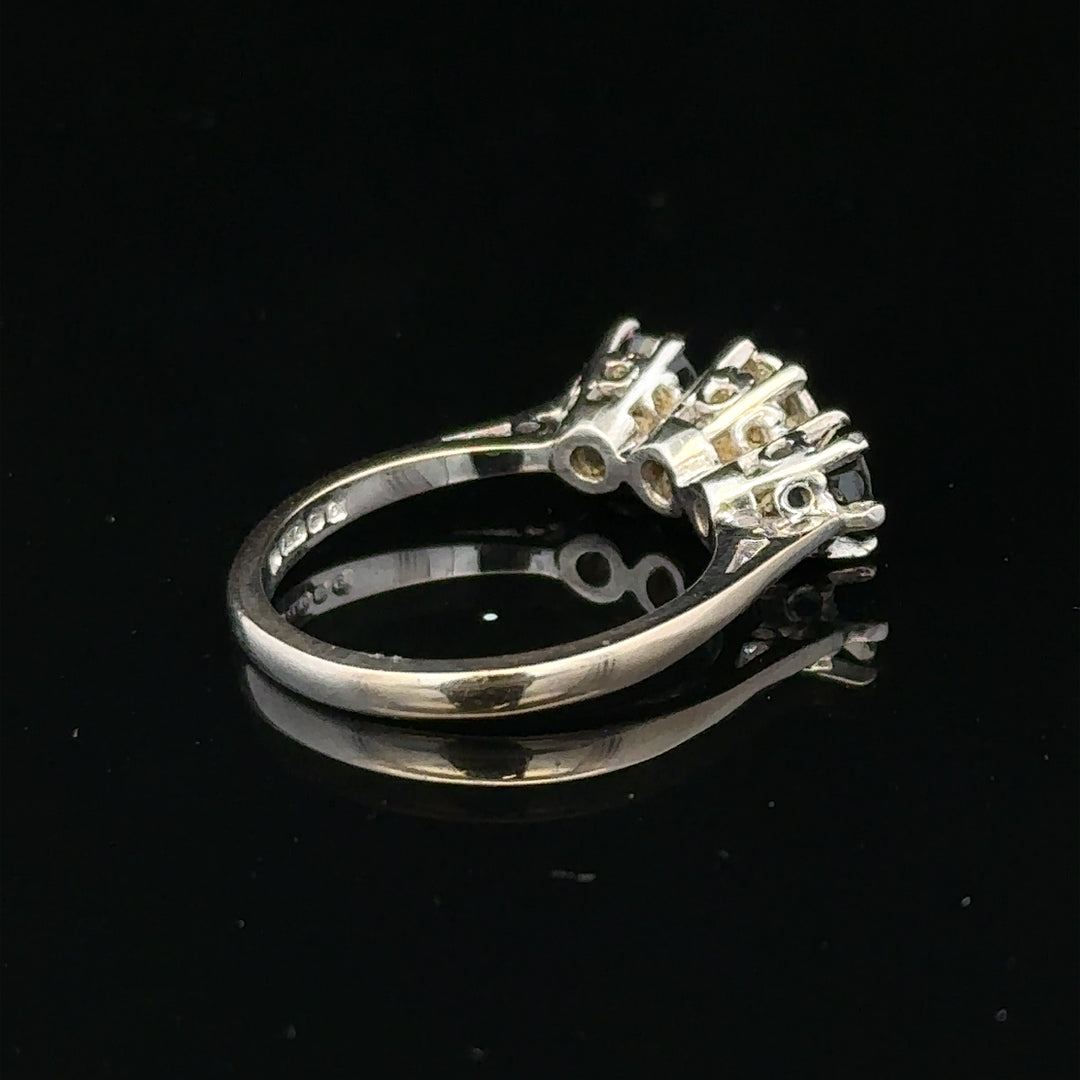 18ct white gold sapphire and diamond ring featuring a central blue sapphire surrounded by sparkling diamonds.