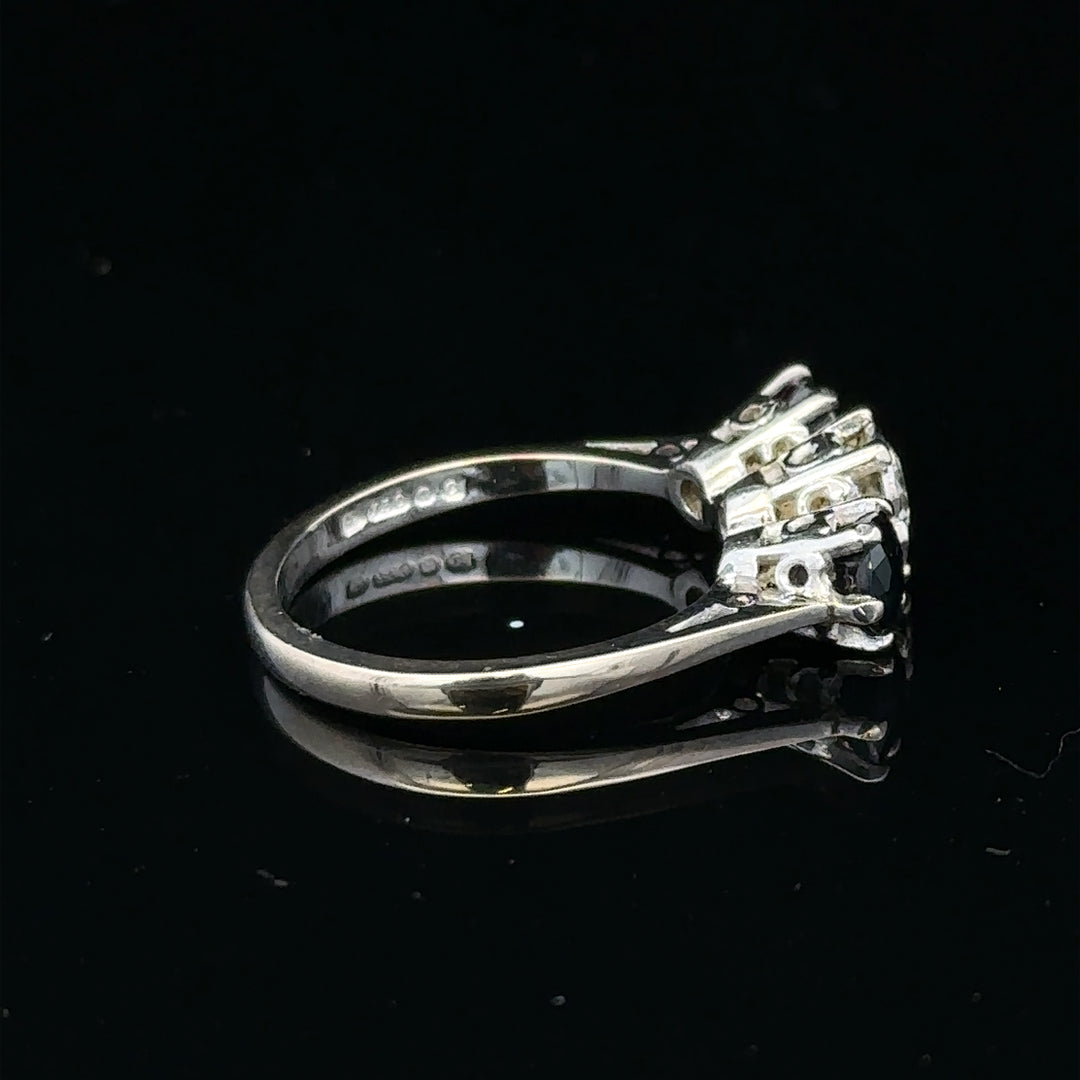 18ct white gold sapphire and diamond ring with a central blue sapphire and sparkling diamonds, elegant jewelry design.
