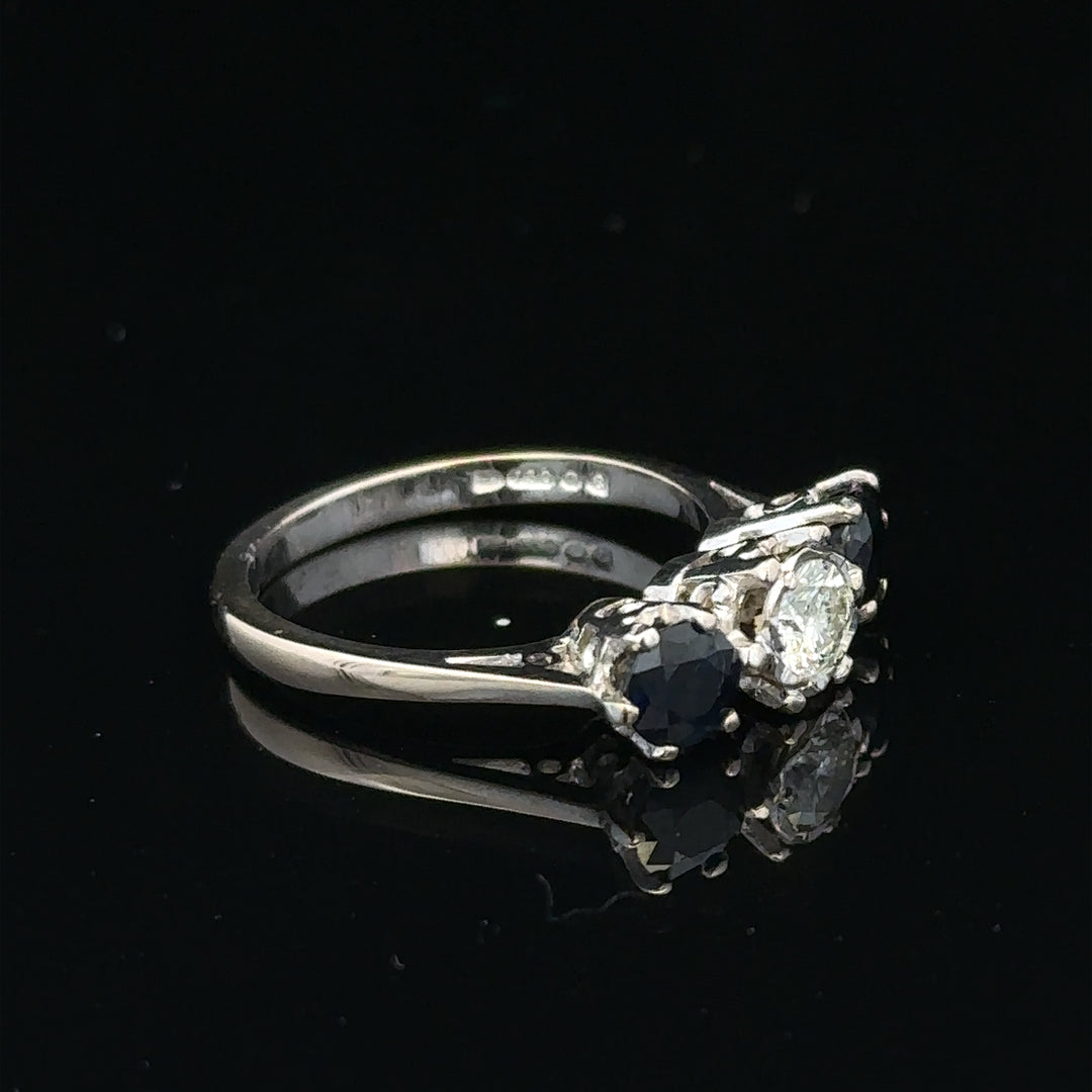 18ct white gold sapphire and diamond ring featuring a central blue sapphire surrounded by sparkling diamonds.