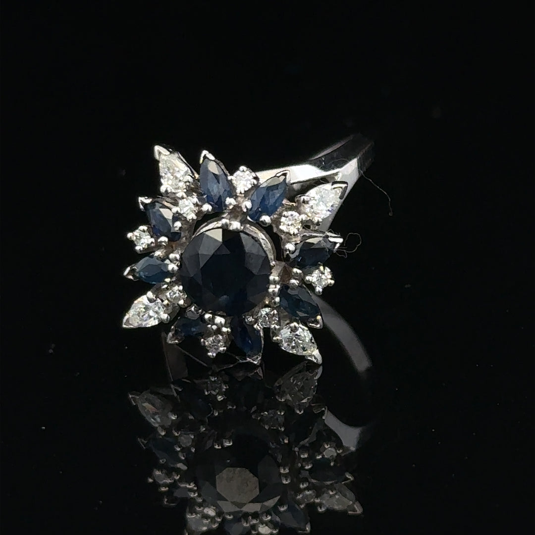 18ct white gold sapphire and diamond ring, size N1/2, featuring a central blue sapphire surrounded by sparkling diamonds.