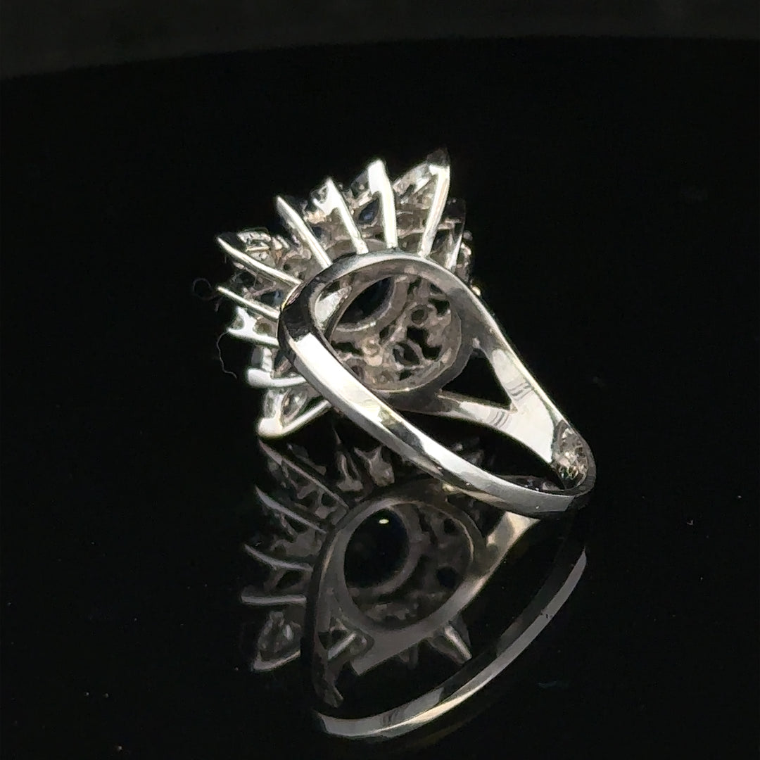 18ct white gold sapphire and diamond ring in size N1/2, featuring a central sapphire surrounded by sparkling diamonds.