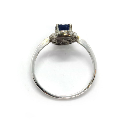 18ct white gold sapphire and diamond ring with a central blue sapphire surrounded by sparkling diamonds.