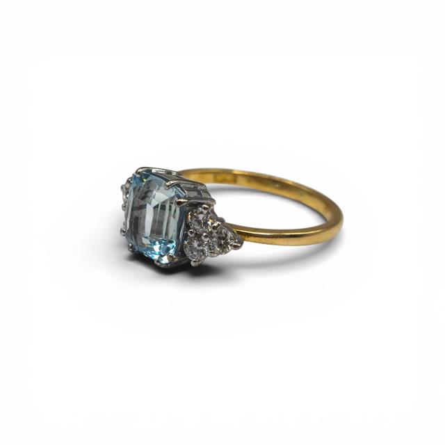 18ct yellow gold aquamarine and diamond ring featuring a central aquamarine stone and sparkling diamonds, elegant jewelry design.
