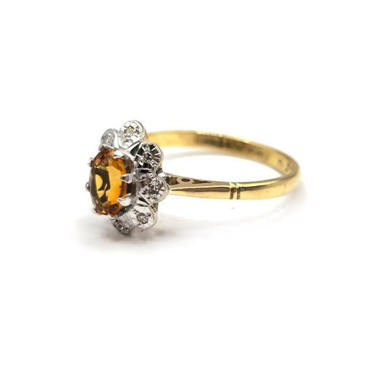 18ct yellow gold citrine and diamond ring with a central citrine gemstone and diamond accents, elegant jewelry piece.