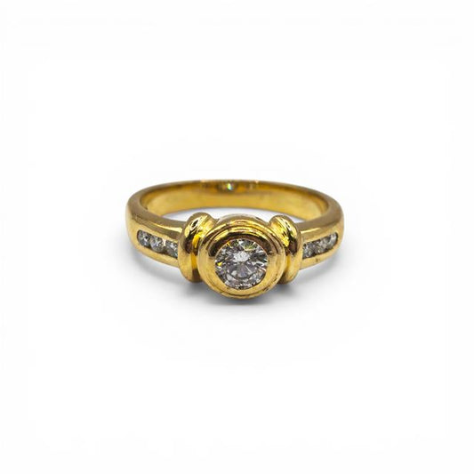 18ct yellow gold diamond ring with a central diamond and intricate band design, unbranded jewelry piece.