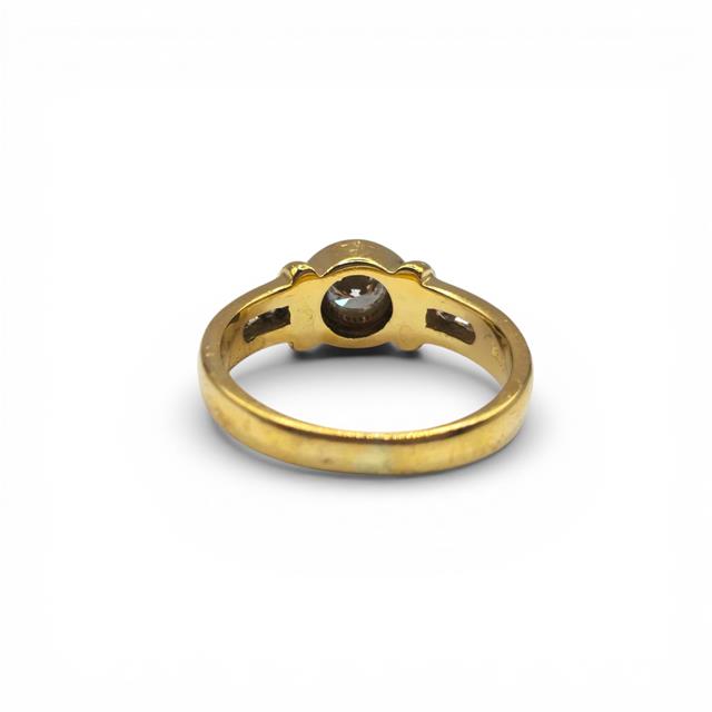18ct yellow gold diamond ring with a central sparkling diamond, elegant design, unbranded jewelry piece.