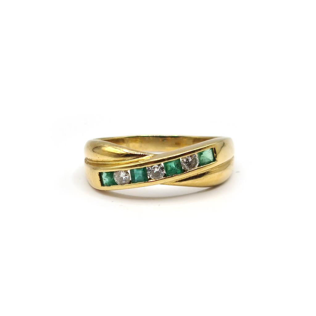 18ct yellow gold emerald and diamond half eternity ring with alternating gemstones and sleek band design.