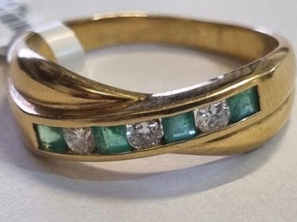 18ct yellow gold emerald and diamond half eternity ring with alternating gemstones and delicate band design.