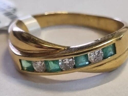 18ct yellow gold emerald and diamond half eternity ring with alternating gemstones and a sleek, polished band.