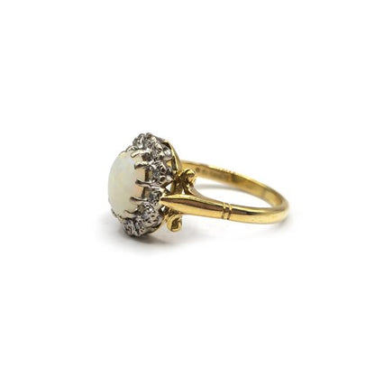 18ct yellow gold opal and diamond ring with a central opal and surrounding diamonds, elegant jewelry design.