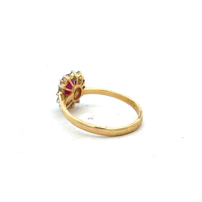 18ct yellow gold ruby and diamond ring, size P, featuring a central ruby gemstone surrounded by sparkling diamonds.