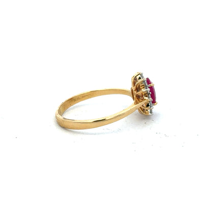 18ct yellow gold ruby and diamond ring in size P, featuring a central ruby surrounded by small sparkling diamonds.