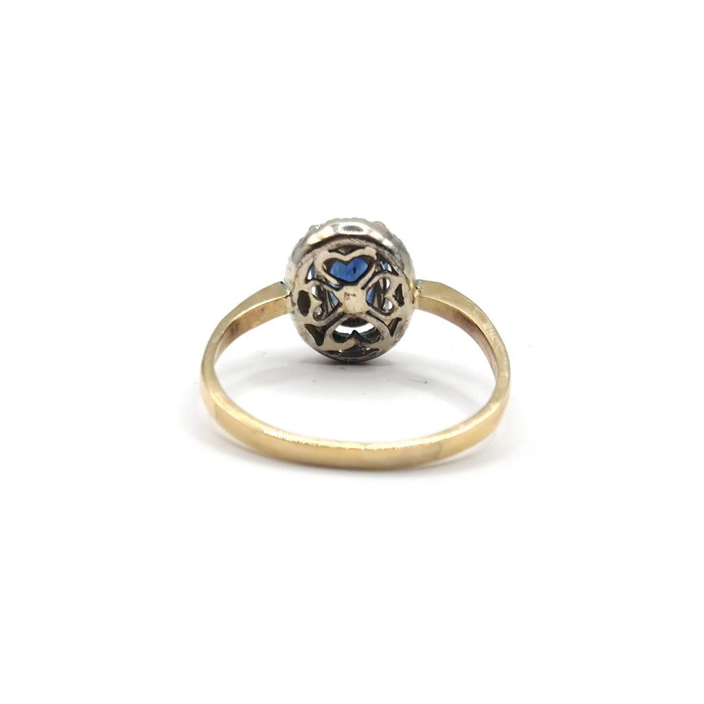18ct yellow gold ring with a sapphire center stone and diamond accents, elegant jewelry piece with a polished finish.