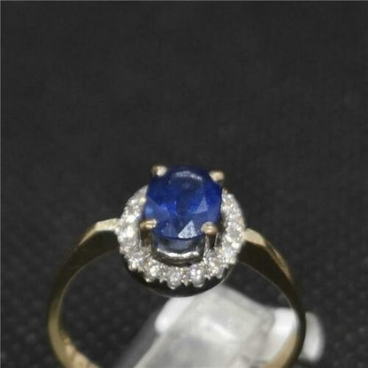 18ct yellow gold sapphire and diamond ring with a central blue sapphire and sparkling diamonds, elegant jewelry design.