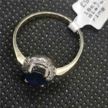 18ct yellow gold sapphire and diamond ring with a central blue sapphire surrounded by small diamonds, elegant jewelry piece.