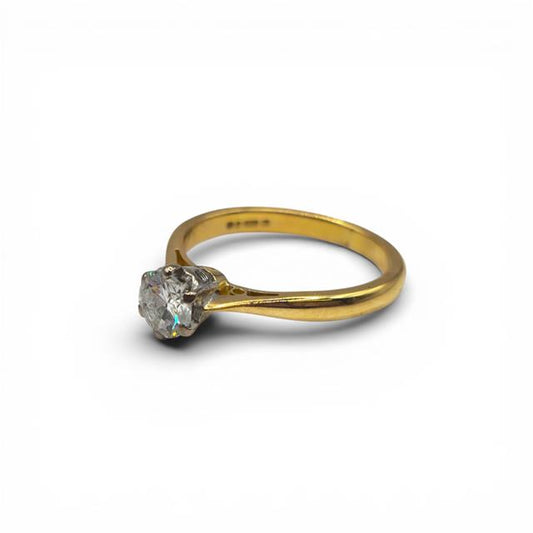 18ct yellow gold diamond ring with a single sparkling stone, featuring a sleek design and elegant craftsmanship.