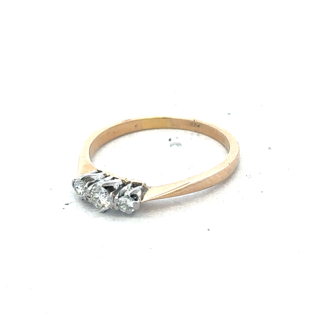 18ct yellow gold three diamond ring with a simple, elegant design and sparkling diamonds on a plain background.