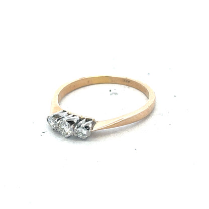18ct yellow gold three diamond ring with a simple, elegant design and sparkling diamonds on a plain background.