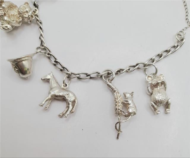 925 silver charm bracelet with decorative charms, unbranded, weighing 27.3g, stylish jewelry accessory.