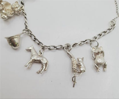925 silver charm bracelet with decorative charms, unbranded, weighing 27.3g, stylish jewelry accessory.
